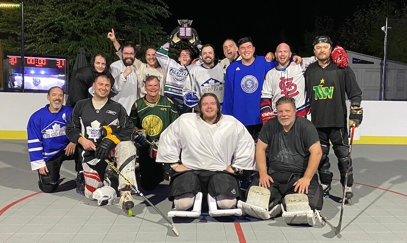 Photo of roller hockey players posing on a hockey rink
