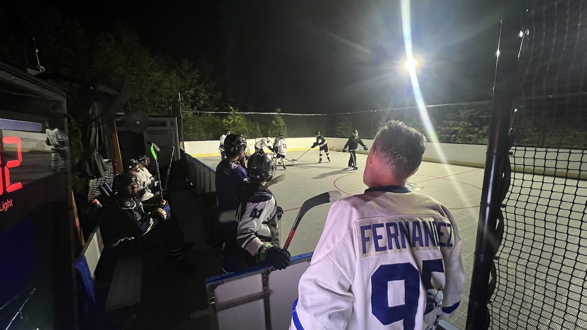 Photo of roller hockey game and players on bench