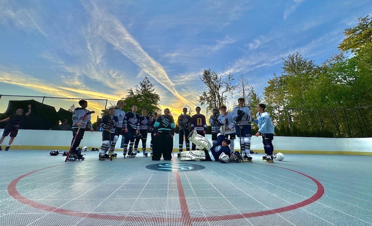 Photo of kids posing after a hockey game with the sky in the background